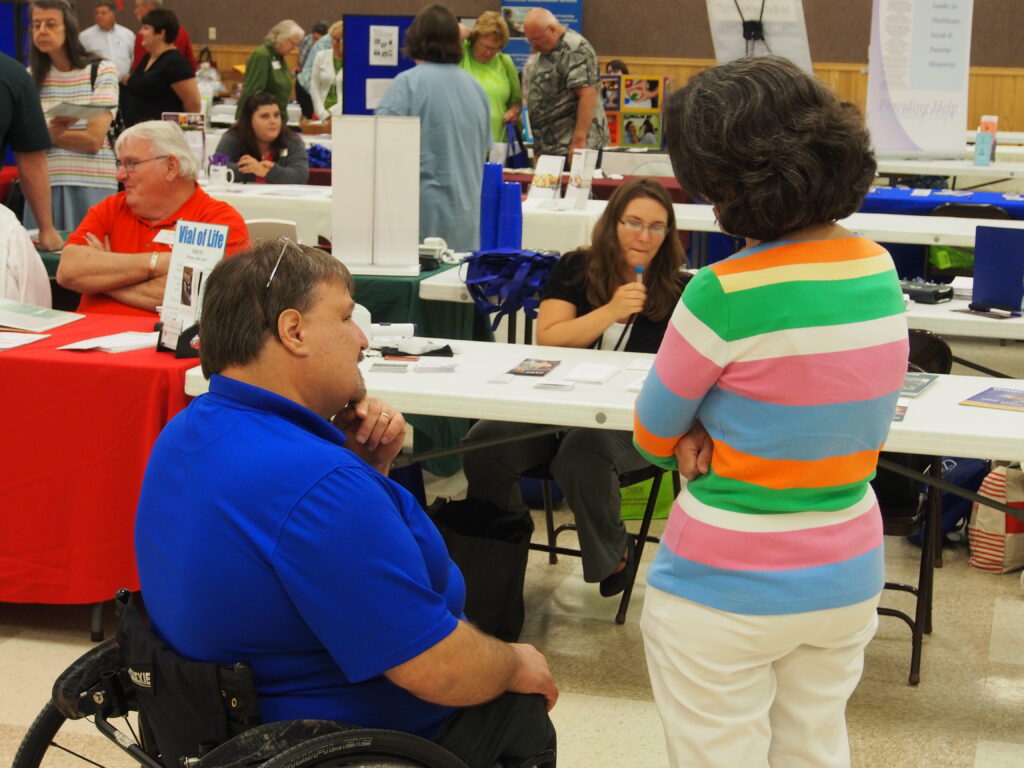 A man in a wheelchair talking to a woman